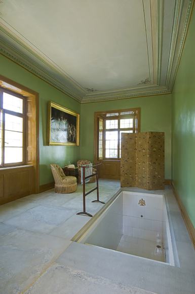 Herzstück des Bades ist ein weiß glasiertes Tauchbecken mit einem fünfstufigen Einstieg und einem goldenen, gekrönten Adler am Kopfende.