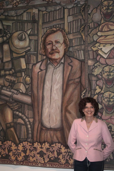 Margret Eicher vor ihrer Tapisserie  „Peter Sloterdijk vor der heiligen Inquisition des Trivialgeschmacks“.