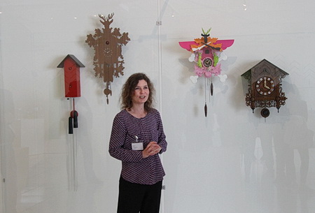 Die Kuratorin der Ausstellung vor der Uhrenwand