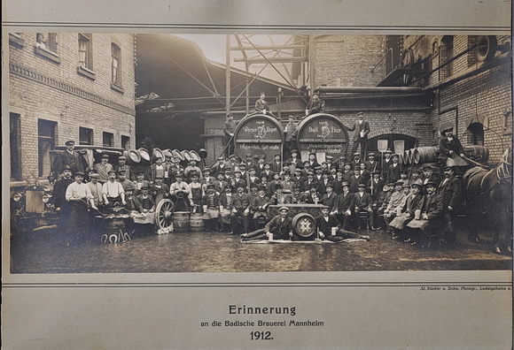 Aufnahme der Mitarbeiter der Badischen Brauerei, Mannheim, 1912. Die Mitarbeiter posieren vor großen Fässern „Wiener Export“ und „Bockbier“ und halten die Werkzeuge ihres Gewerbes in den Händen. © Technoseum Mannheim
