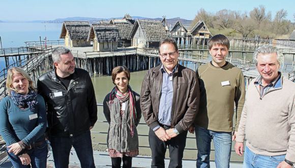 Teilnehmer an der Internationalen Tagung zur Unterwasserarch&auml;ologie „In Poseidons Reich XIX“ vor der Kulisse der rekonstruierten Pfahlbauten: (von links) Elena Pranckenaite (Vilnius, Litauen), Igor Miholjek (Leiter des Departments f&uuml;r Unterwasserarch&auml;ologie in Kroatien), Antonia Sciancalepore (Forschungszentrum „Lago Bolsena“ in Italien), Gunter Sch&ouml;bel (Pfahlbaumuseum Unteruhldingen), Segey Olkhovskiy (Arch&auml;ologisches Institut der Akademie der Wissenschaften, Russische F&ouml;deration) und Hanz G&uuml;nter Martin (Vizedirektor der Deutschen Gesellschaft f&uuml;r Unterwasserarch&auml;ologie). &copy; Walter/Pfahlbauten