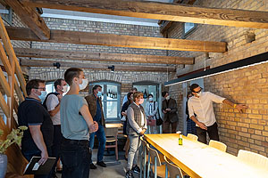 Ministerin Nicole Razavi MdL (Mitte) lässt sich beim Besuch der Tabakscheunen in Rheinstetten die historischen Graffiti aus der Zeit des 2. Weltkriegs erklären. 