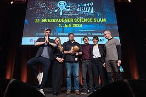 Konnte sich im interdisziplinären Bewerberfeld beim 21. Wiesbadener Science Slam durchsetzen: Archäologe Frederic Auth (3. von links) von der Goethe-Universität mit Moderator Rainer Holl (von links) und den Science Slammern Maria Bruhnke, Christopher Synatschke, Nina Lanzer und Uwe Gaitzsch. (Foto: science-slam.com)