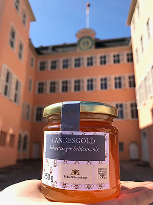 Schlosshonig "Landesgold" der Staatlichen Schlösser und Gärten vor der Kulisse des Schwetzinger Schlosses. Foto: Katja Nowotny, ssg.