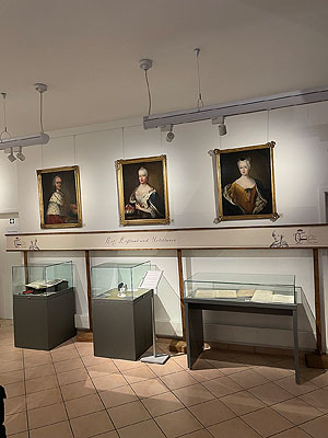 Blick in die Ausstellung. An der Wand Porträts der fürstlichen Familie