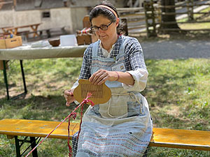 Webmeisterin Gabriela Martin bei der alten Handarbeitstechnik des Bandwebens. Foto: Schwarzwälder Freilichtmuseum Vogtsbauernhof, Tamara Vogt