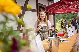 Eine strahlende Winzerin präsentiert Ortenauer Wein. Foto: Schwarzwälder Freilichtmuseum Vogtsbauernhof, Hans-Jörg Haas
