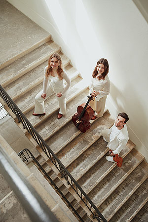 Zwei Musikerinnen und ein Musiker auf einer Treppe