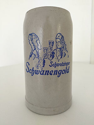 Bierkrug der Schwetzinher Schwanenbrauerei mit der Aufschrift "Schwetzinger Schwanengold".